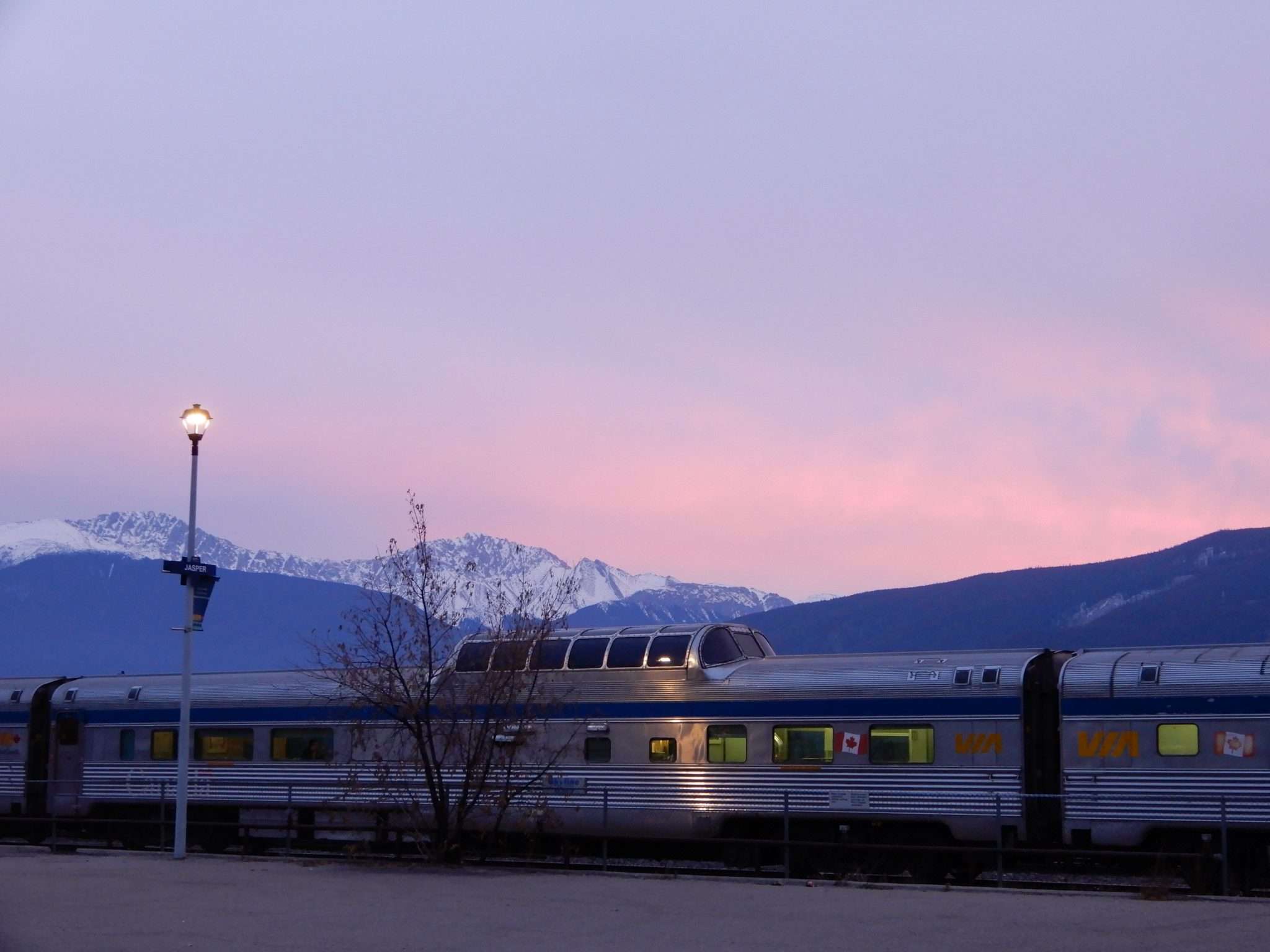 VIA Rail in Jasper, Alberta, showcasing the majestic Canadian Rockies during a scenic train journey.